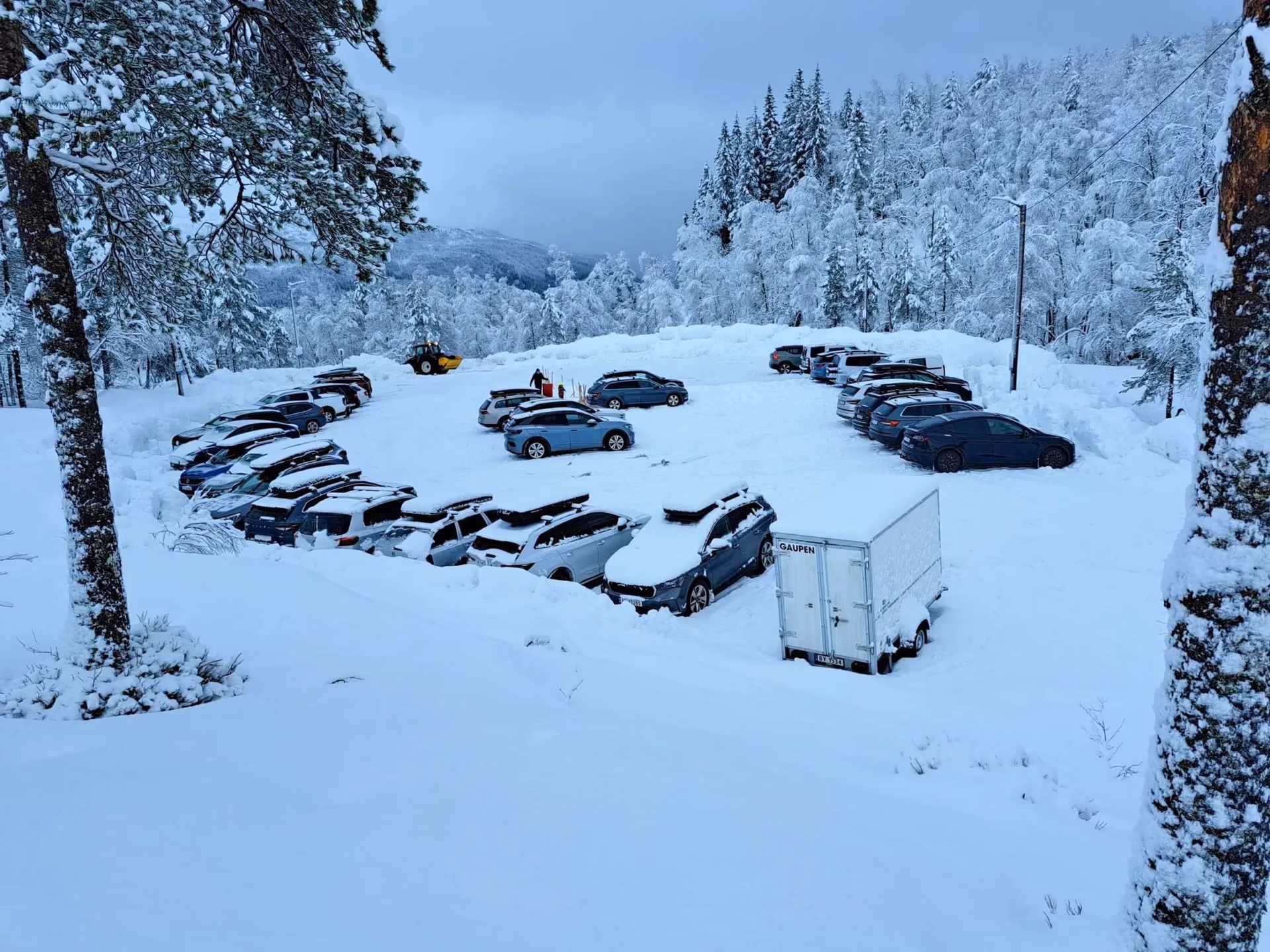 Parkeringsplass ved Totræna Vinterpark med biler og snø